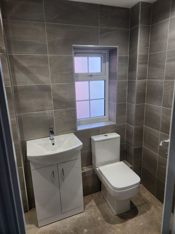 Tiled cloakroom with a basin unit and toilet