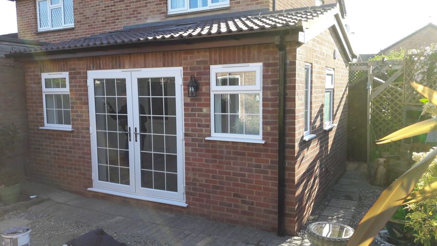 Brick garden room extension with French doors and a pitched tiled roof