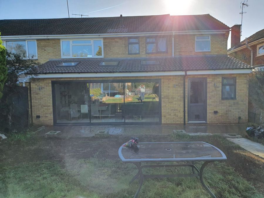 Yellow brick rear extension with wide sliding doors and roof windows