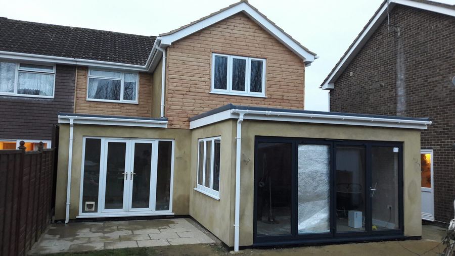 Two storey extension with timber cladding above a rendered ground floor